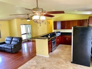 18-7856 Kaniela Road Mountain View, HI 96771 - Photo 4 of 30 a kitchen with stainless steel appliances granite countertop a refrigerator a sink dishwasher a stove a dining table and chairs with wooden floor