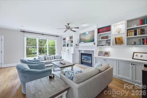 a living room with furniture fireplace and a large window