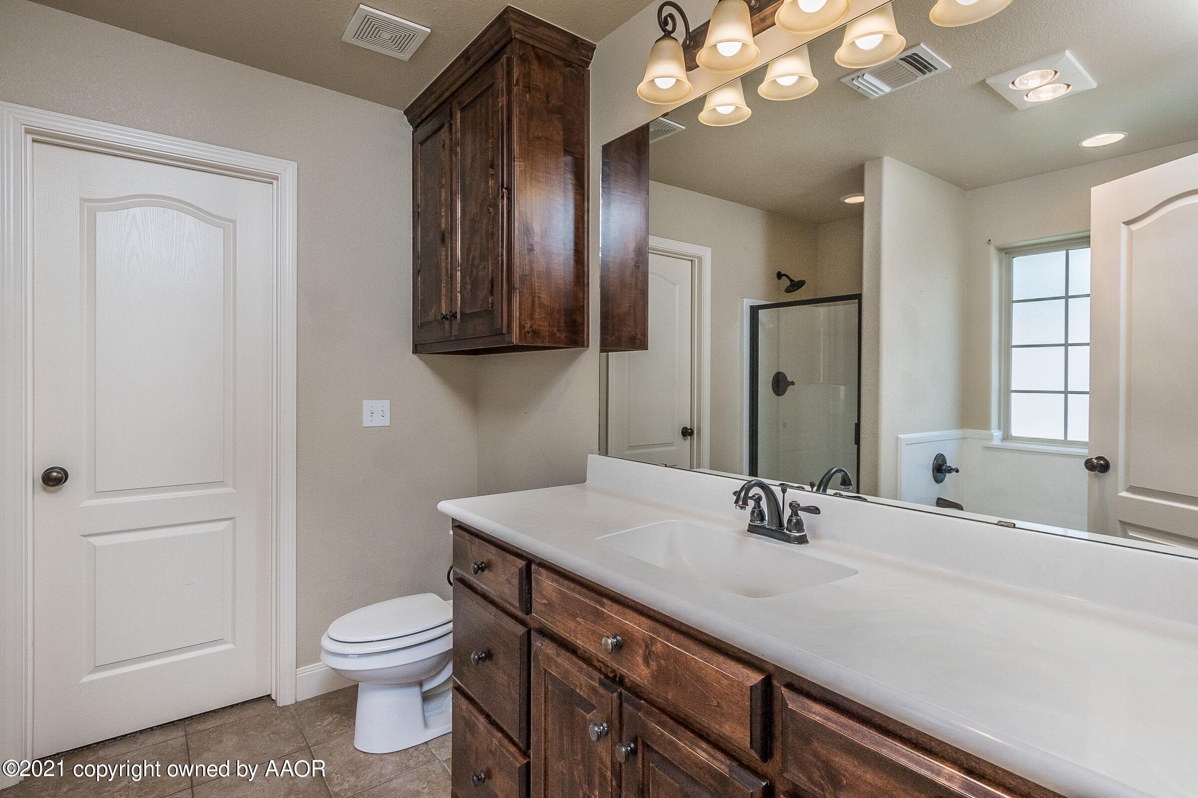3908 Arden Road Amarillo, TX 79118 - Photo 12 of 25 a bathroom with a sink a toilet and a mirror