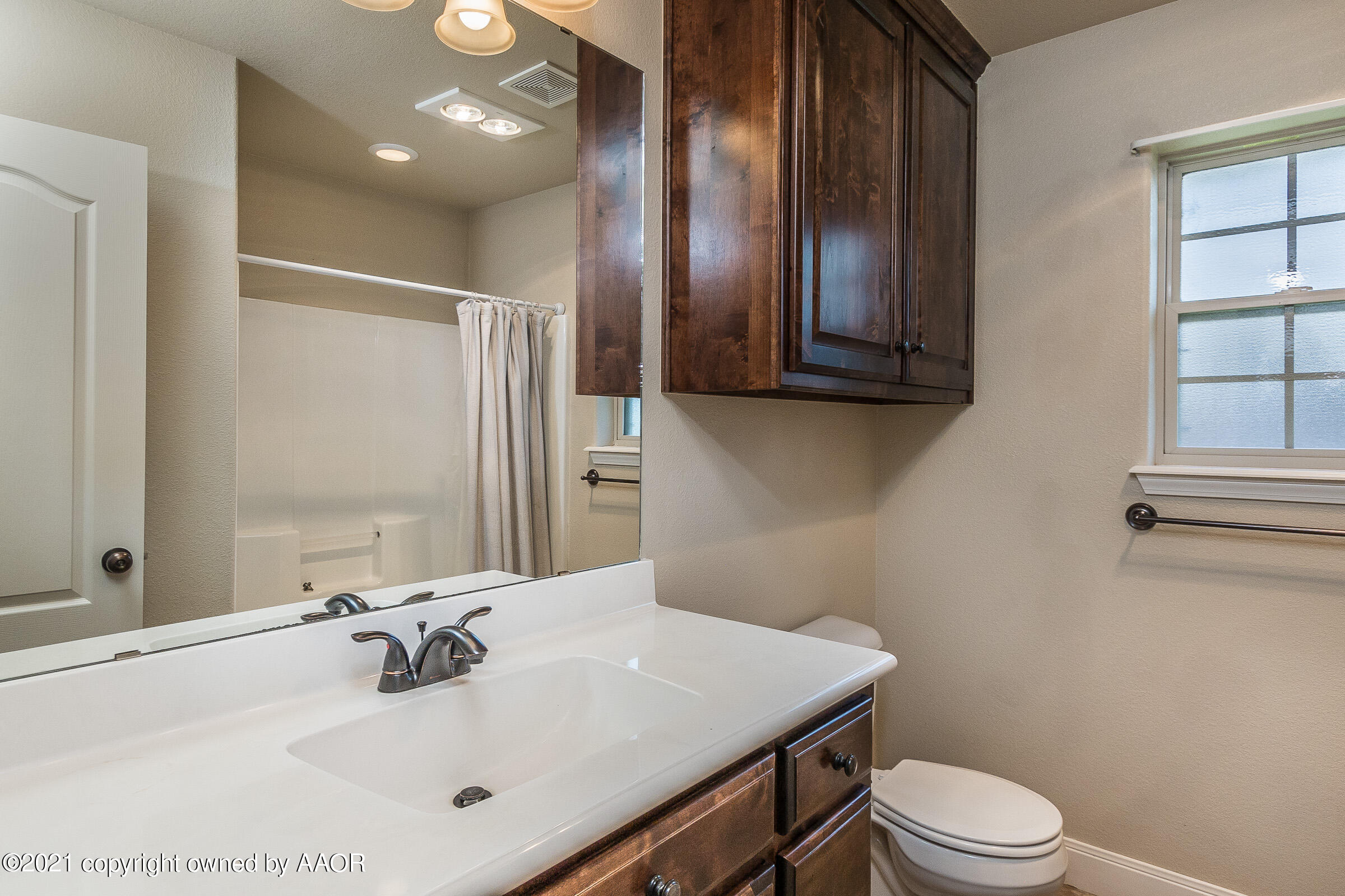 3908 Arden Road Amarillo, TX 79118 - Photo 17 of 25 a bathroom with a sink a toilet and mirror