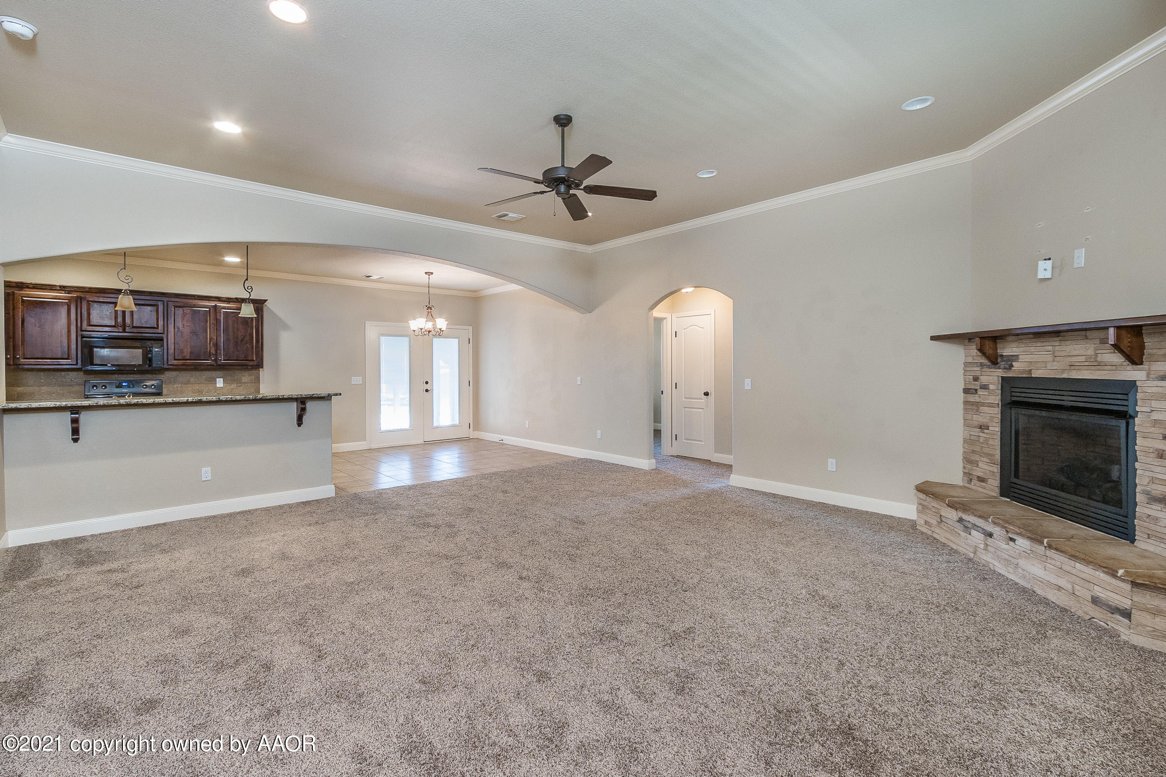 3908 Arden Road Amarillo, TX 79118 - Photo 3 of 25 an empty room with a fireplace and chandelier fan