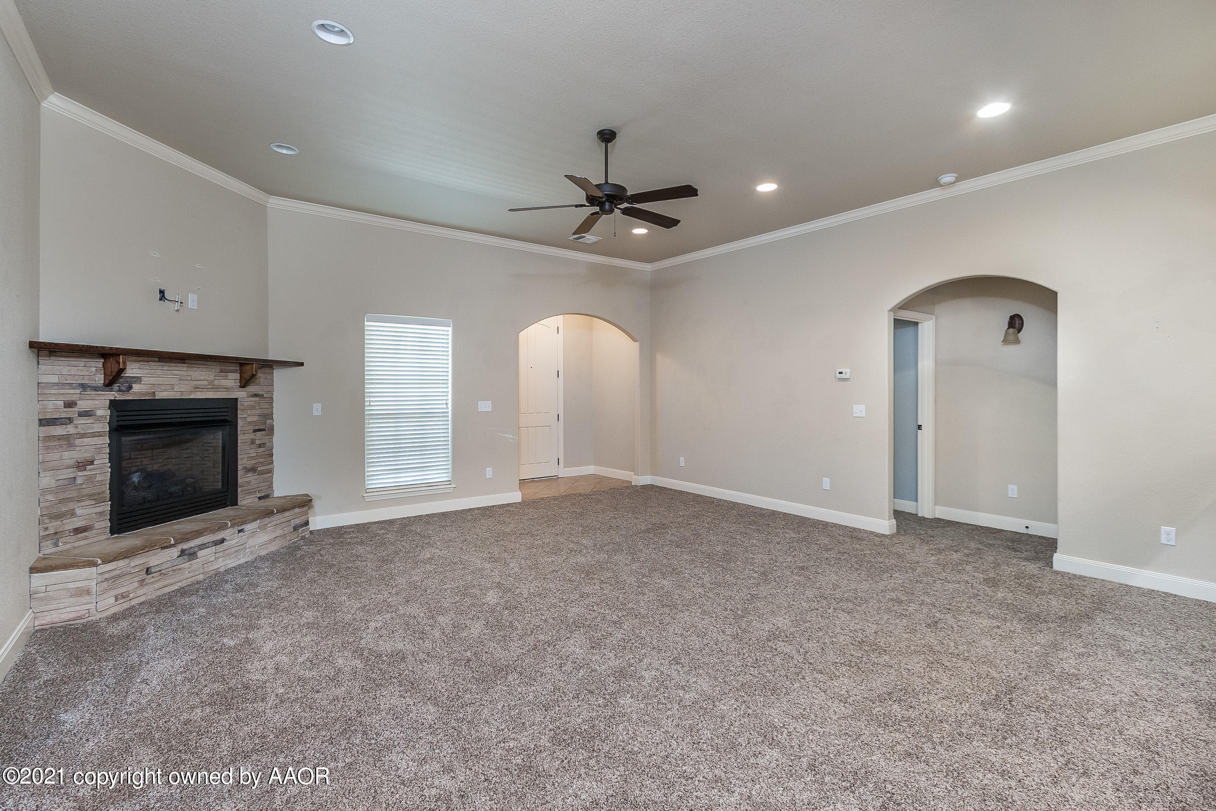 3908 Arden Road Amarillo, TX 79118 - Photo 4 of 25 an empty room with fireplace and fan