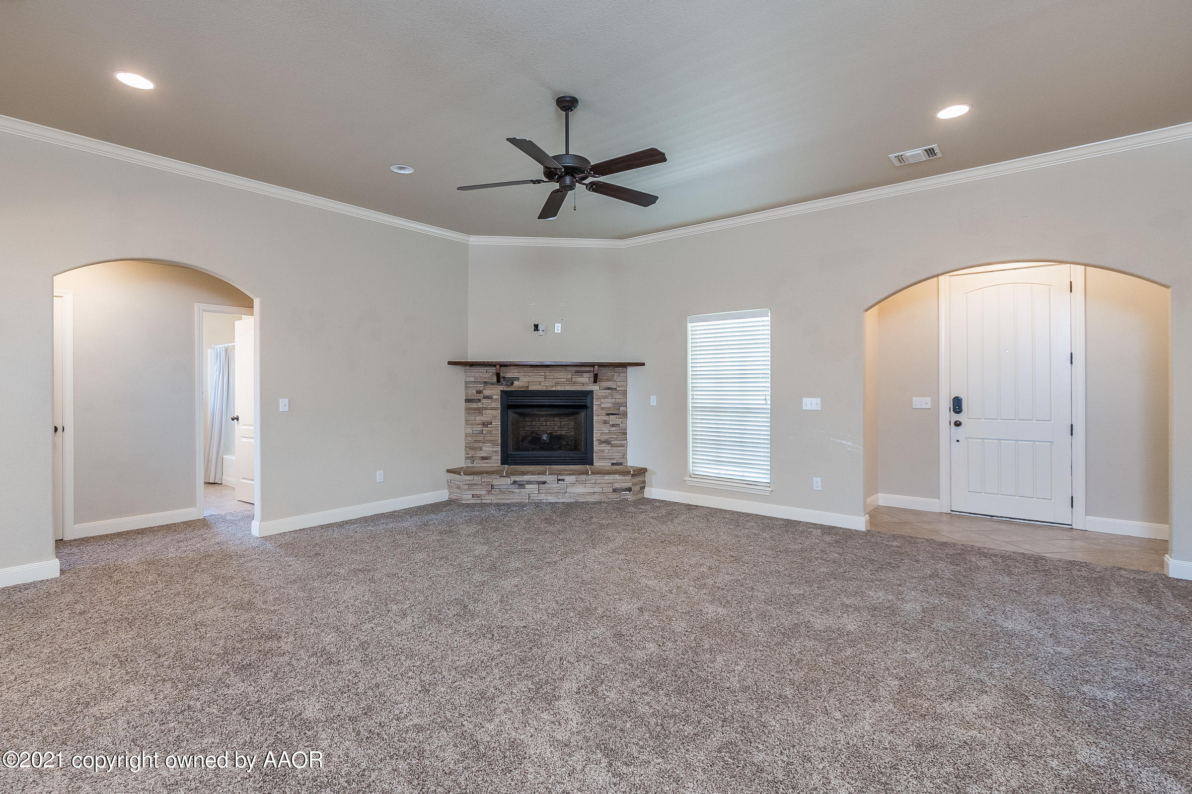 3908 Arden Road Amarillo, TX 79118 - Photo 5 of 25 an empty room with a fireplace and a ceiling fan