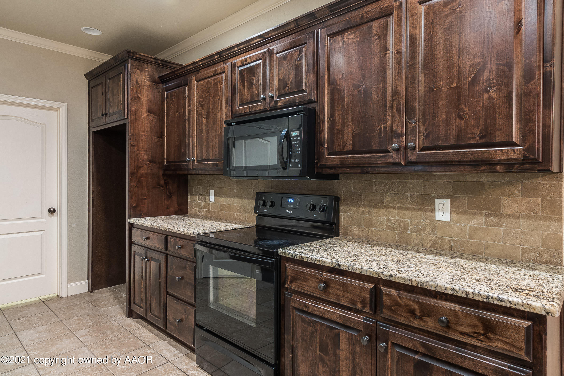 3908 Arden Road Amarillo, TX 79118 - Photo 7 of 25 a kitchen with granite countertop a stove and a microwave
