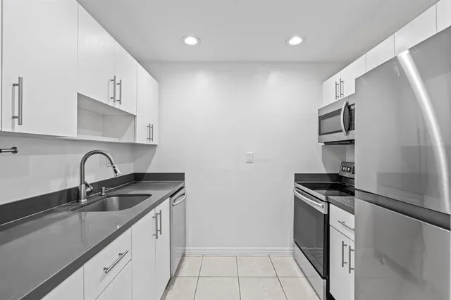 a kitchen that has a sink stainless steel appliances and cabinets