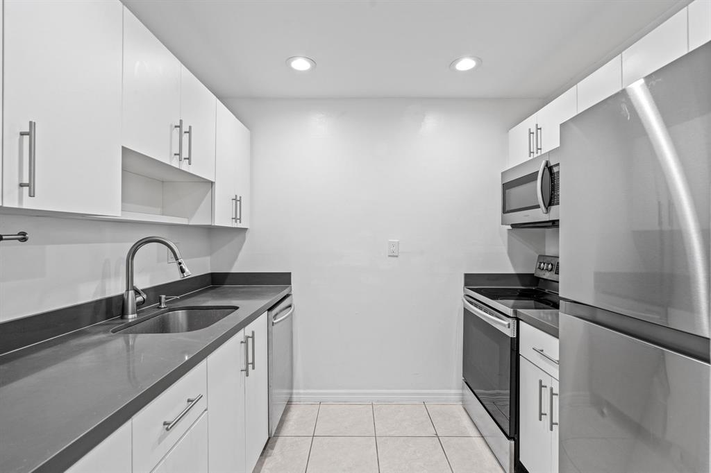 9225 Southwest 87th Avenue, Unit A7 Miami, FL 33176 - Photo 5 of 35 a kitchen that has a sink stainless steel appliances and cabinets