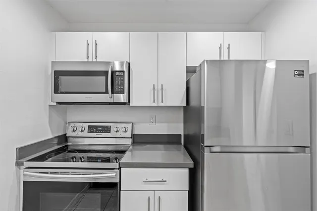 a kitchen with stainless steel appliances white cabinets and a stove