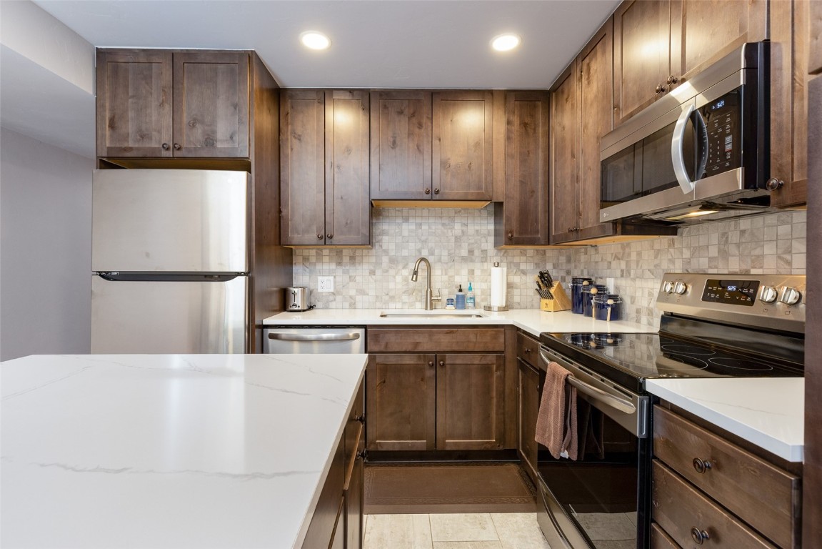 500 Bills Ranch Road, Unit 251 Frisco, CO 80443 - Photo 5 of 33 a kitchen with stainless steel appliances granite countertop a refrigerator a sink dishwasher a stove and white cabinets with wooden floor
