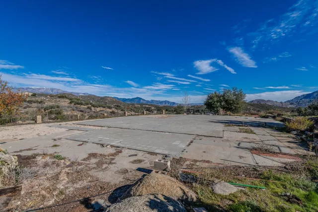 a view of a dry yard with wooden fence