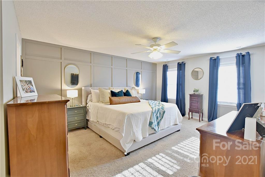 2984 Timber Ridge Lane Rock Hill, SC 29732 - Photo 18 of 32 a spacious bedroom with a bed and a chandelier