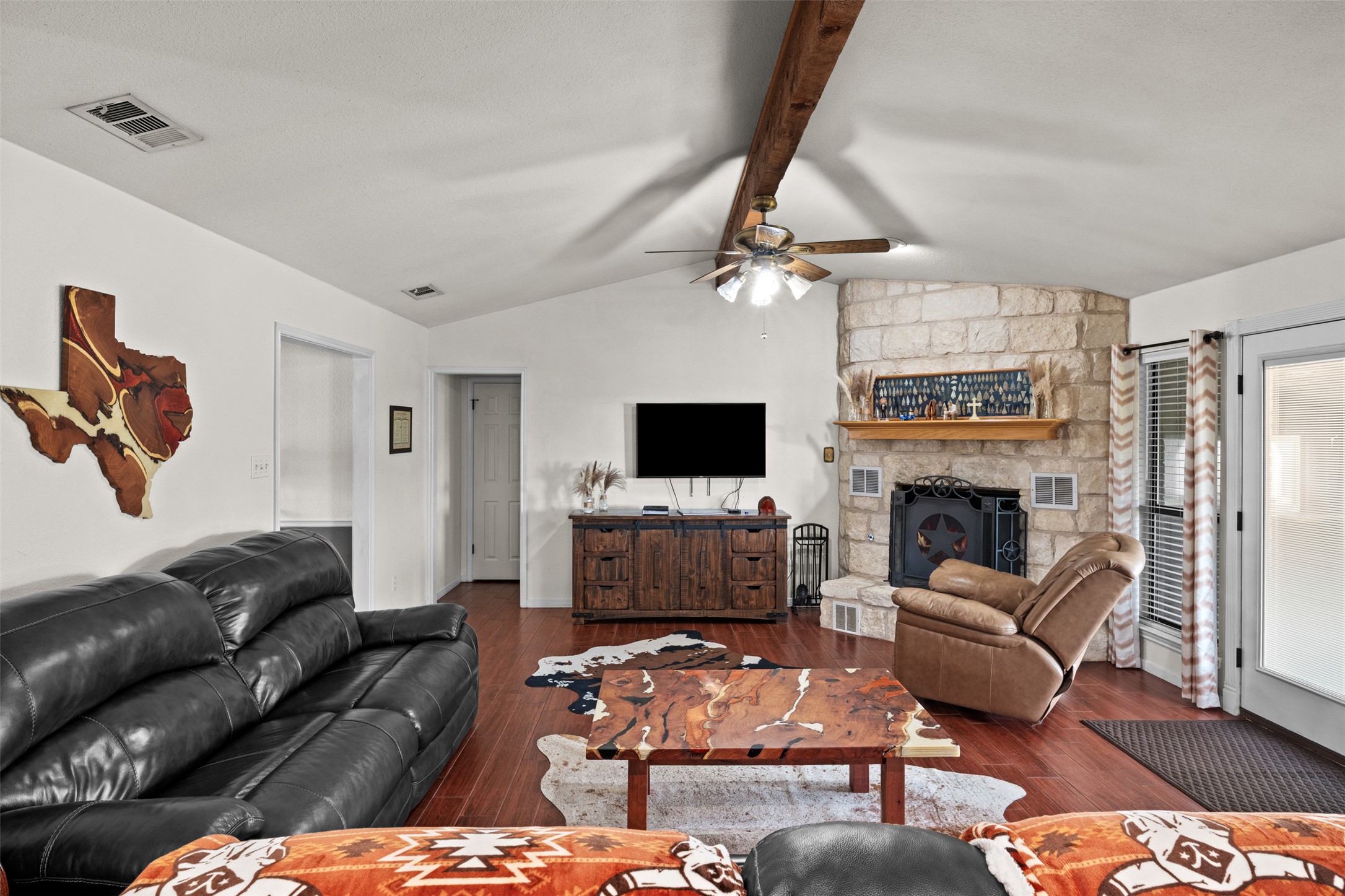 1512 Panther Loop Pflugerville, TX 78660 - Photo 21 of 40 A spacious living room features vaulted ceilings, rich hardwood flooring, and a commanding stone fireplace.