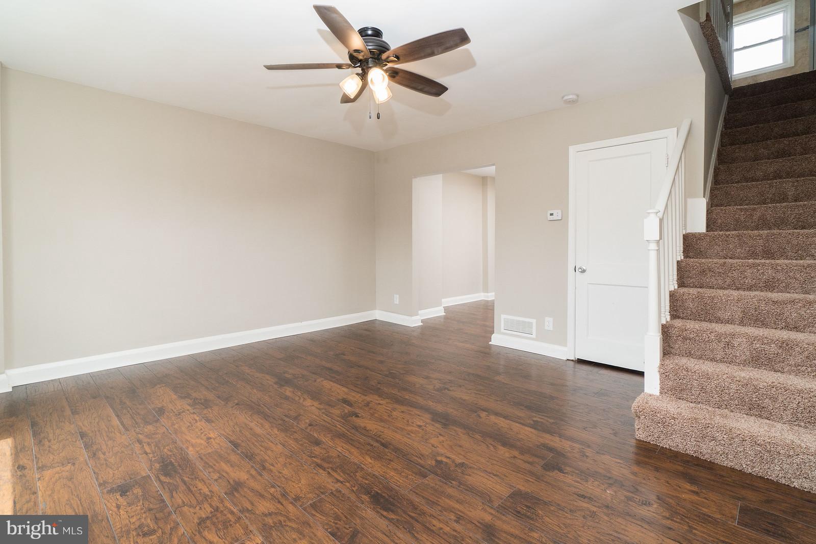 2113 Coralthorn Road Baltimore, MD 21220 - Photo 4 of 24 a view of an empty room with wooden floor and a ceiling fan