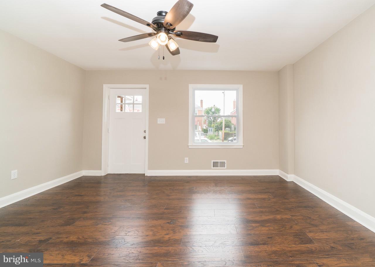 2113 Coralthorn Road Baltimore, MD 21220 - Photo 6 of 24 an empty room with wooden floor chandelier fan and windows