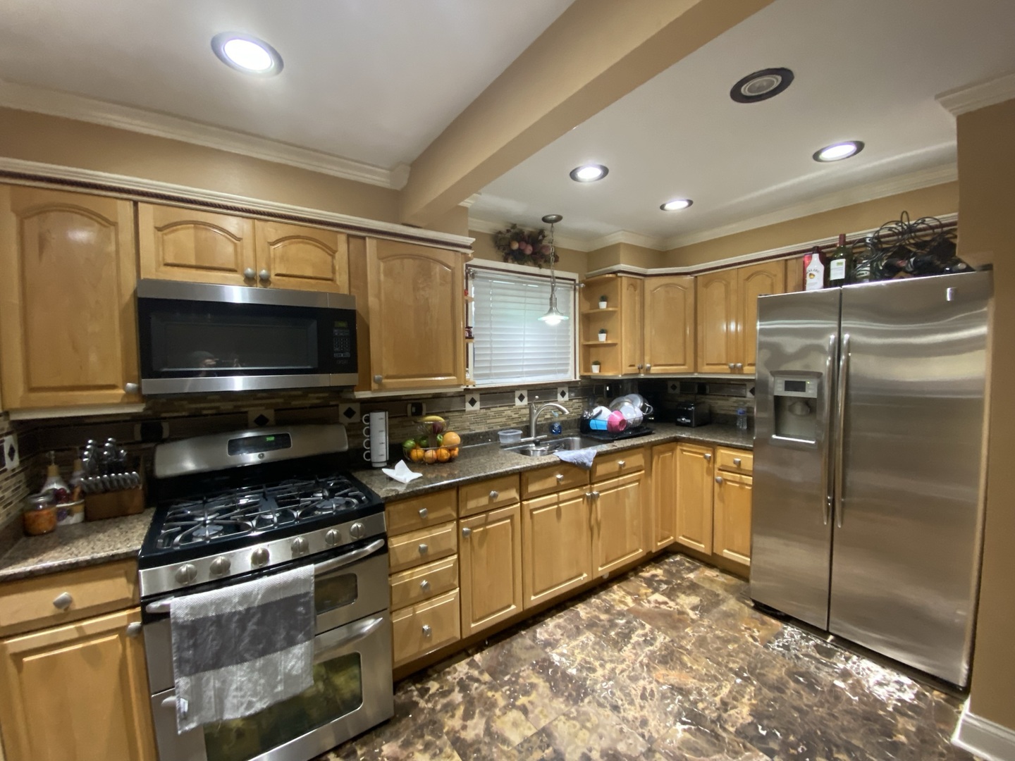 529 Julie Road Bolingbrook, IL 60440 - Photo 11 of 12 a kitchen with stainless steel appliances granite countertop a stove a sink and a refrigerator