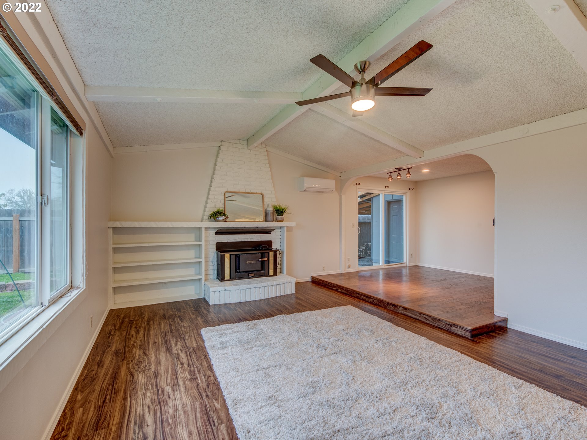 252 71st Street Springfield, OR 97478 - Photo 5 of 30 a living room with a fireplace furniture a ceiling fan and a large window