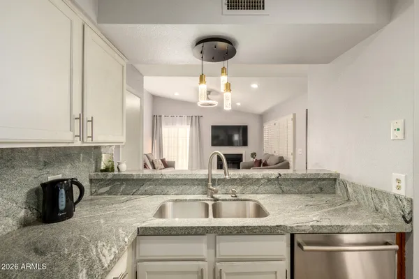 a kitchen with kitchen island a sink stainless steel appliances and a counter top space