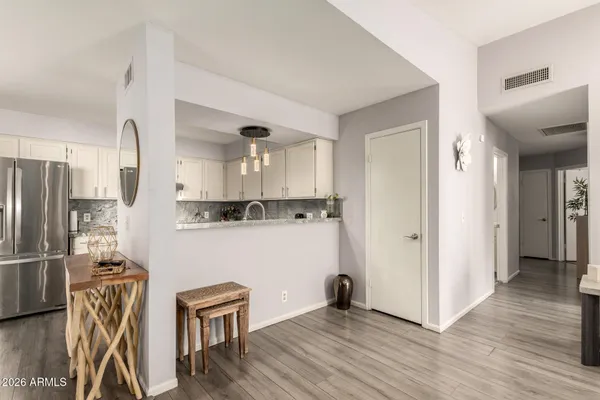 a kitchen with stainless steel appliances granite countertop a refrigerator a stove and a wooden floors