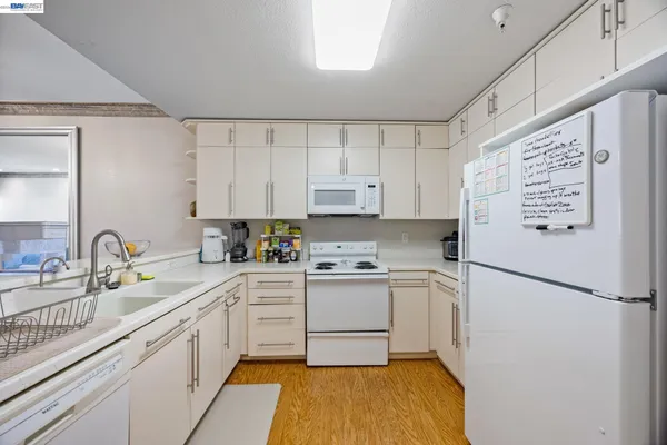 a kitchen with a sink cabinets stainless steel appliances and a window