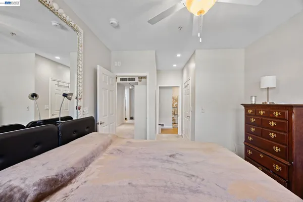 a spacious bedroom with a bed and a dresser