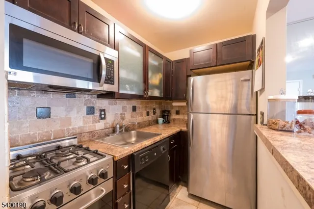 a kitchen with stainless steel appliances granite countertop a refrigerator stove and sink