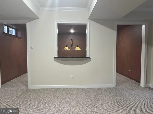 an empty room with a hallway and wooden floor