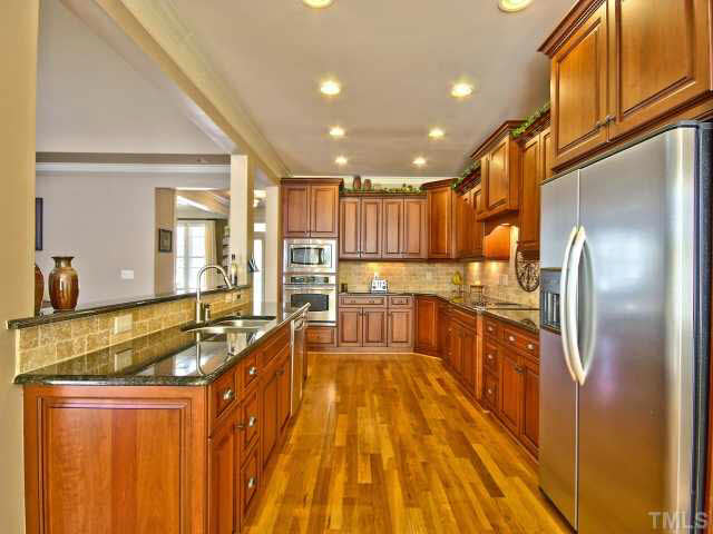 9705 Bailey Grove Court Raleigh, NC 27613 - Photo 7 of 25 a large kitchen with kitchen island a large counter top stainless steel appliances and cabinets