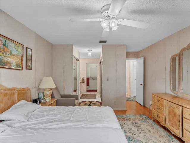 a spacious bedroom with a bed a couch and dresser