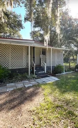 a view of a house with backyard and a garden