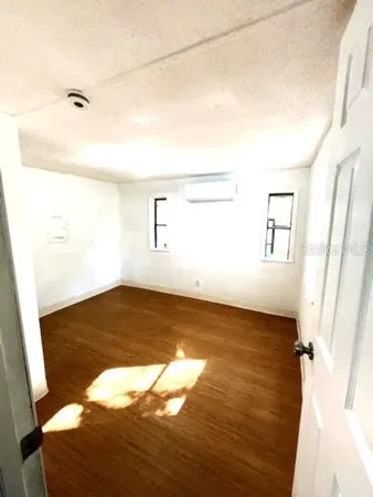 a view of a room with wooden floor and window