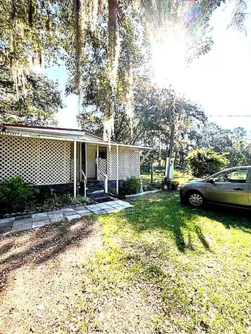 a view of a house with backyard and sitting area