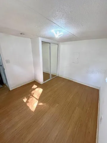 an empty room with wooden floor and natural light