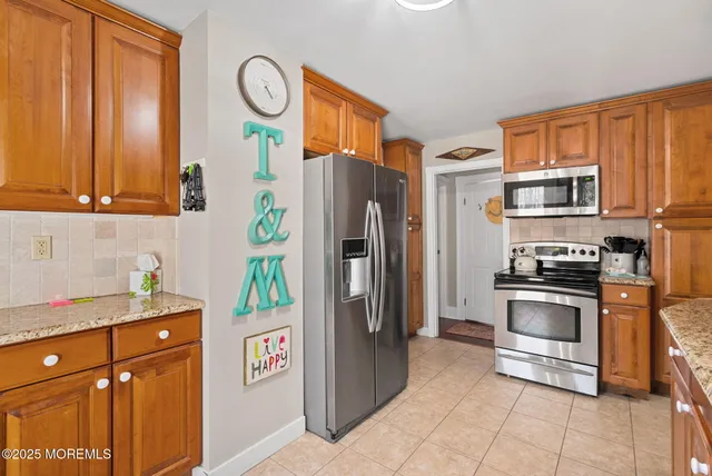 a kitchen with stainless steel appliances granite countertop a refrigerator and a stove top oven