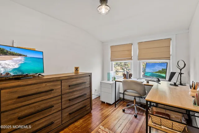 a view of a workspace with furniture and a flat screen tv