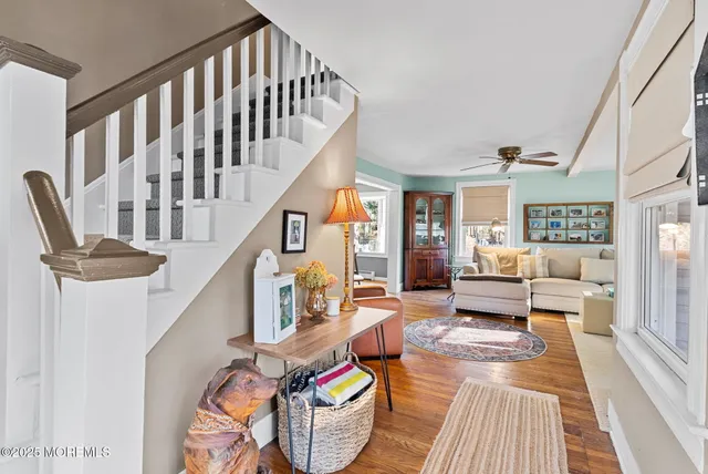 a living room with furniture stairs and a rug