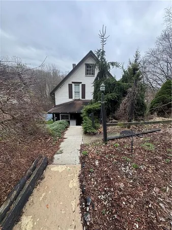 a front view of a house with a yard and mountain view