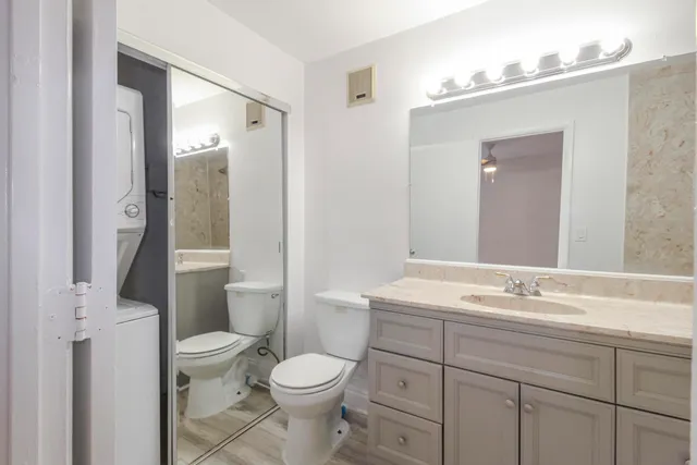 a bathroom with a sink a toilet a mirror and shower