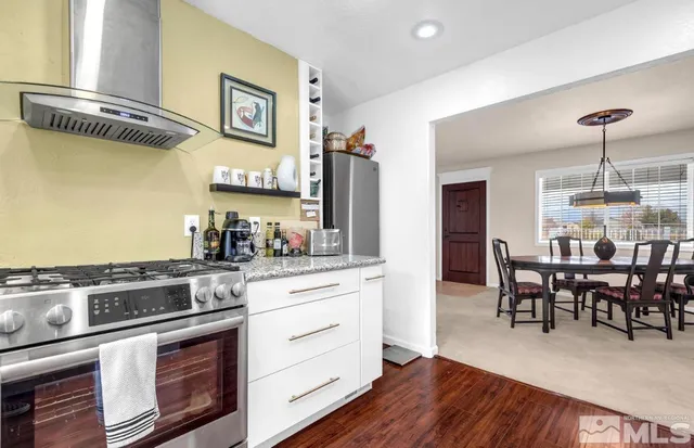 a kitchen with stainless steel appliances a stove a sink dishwasher and cabinets with wooden floor