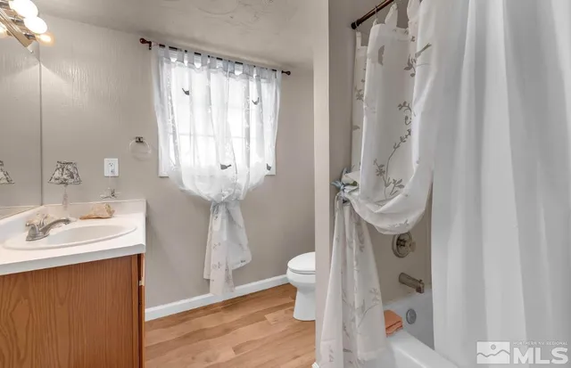 a bathroom with a sink a toilet and shower curtain