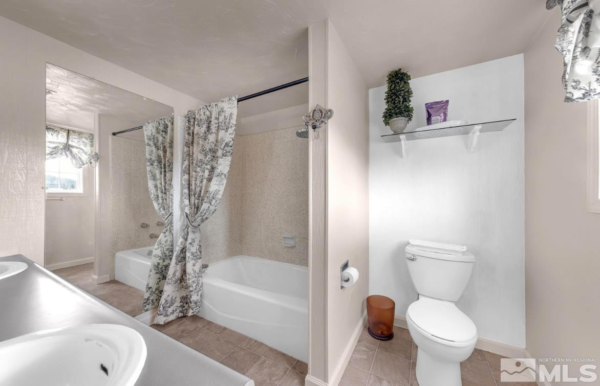 990 Riverview Drive Gardnerville, NV 89460 - Photo 22 of 40 a bathroom with a toilet a sink and bathtub
