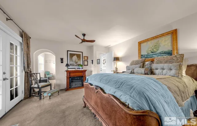 a spacious bedroom with a balcony a bed and dresser