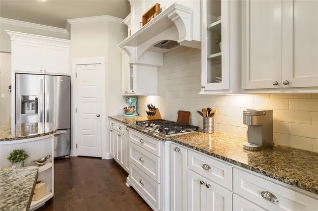 a kitchen with granite countertop a sink stainless steel appliances and cabinets