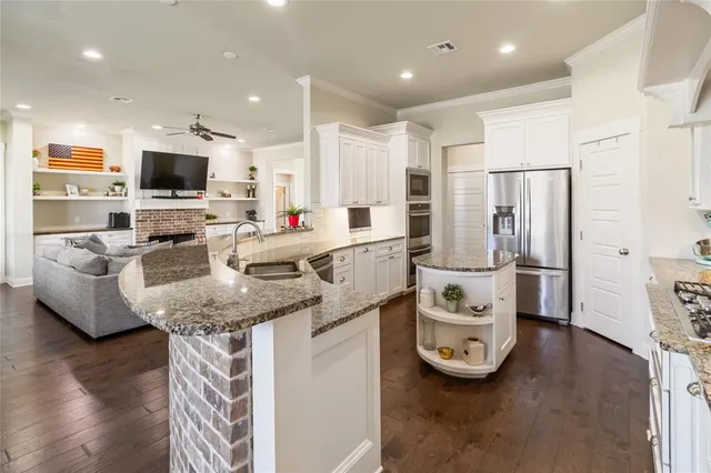 a kitchen with stainless steel appliances granite countertop a sink refrigerator and microwave