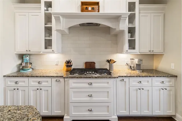 a kitchen with granite countertop white cabinets and white appliances