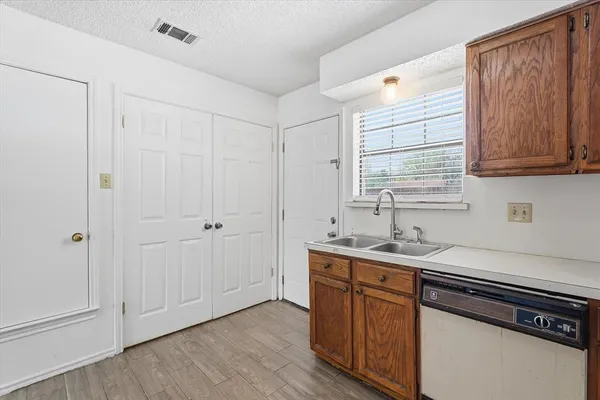 a kitchen with a sink cabinets and wooden floor