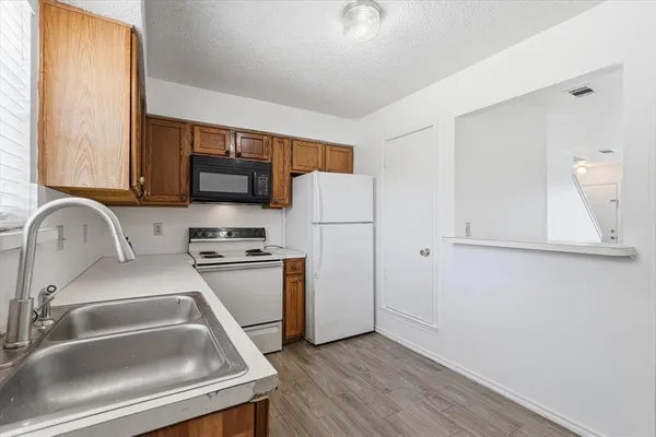 a kitchen with a refrigerator sink and cabinets