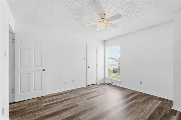 an empty room with a ceiling fan and a rug