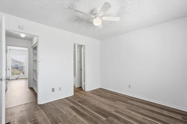 a view of a room with wooden floor and a ceiling fan