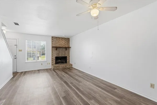 an empty room with windows and fireplace