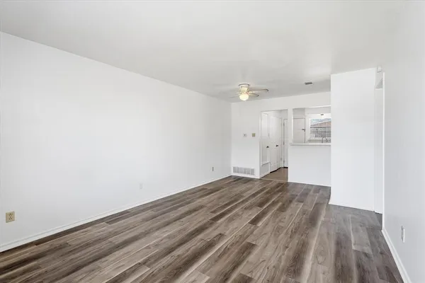 a view of empty room with wooden floor