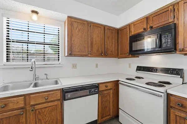 a kitchen with stainless steel appliances granite countertop a sink stove and microwave